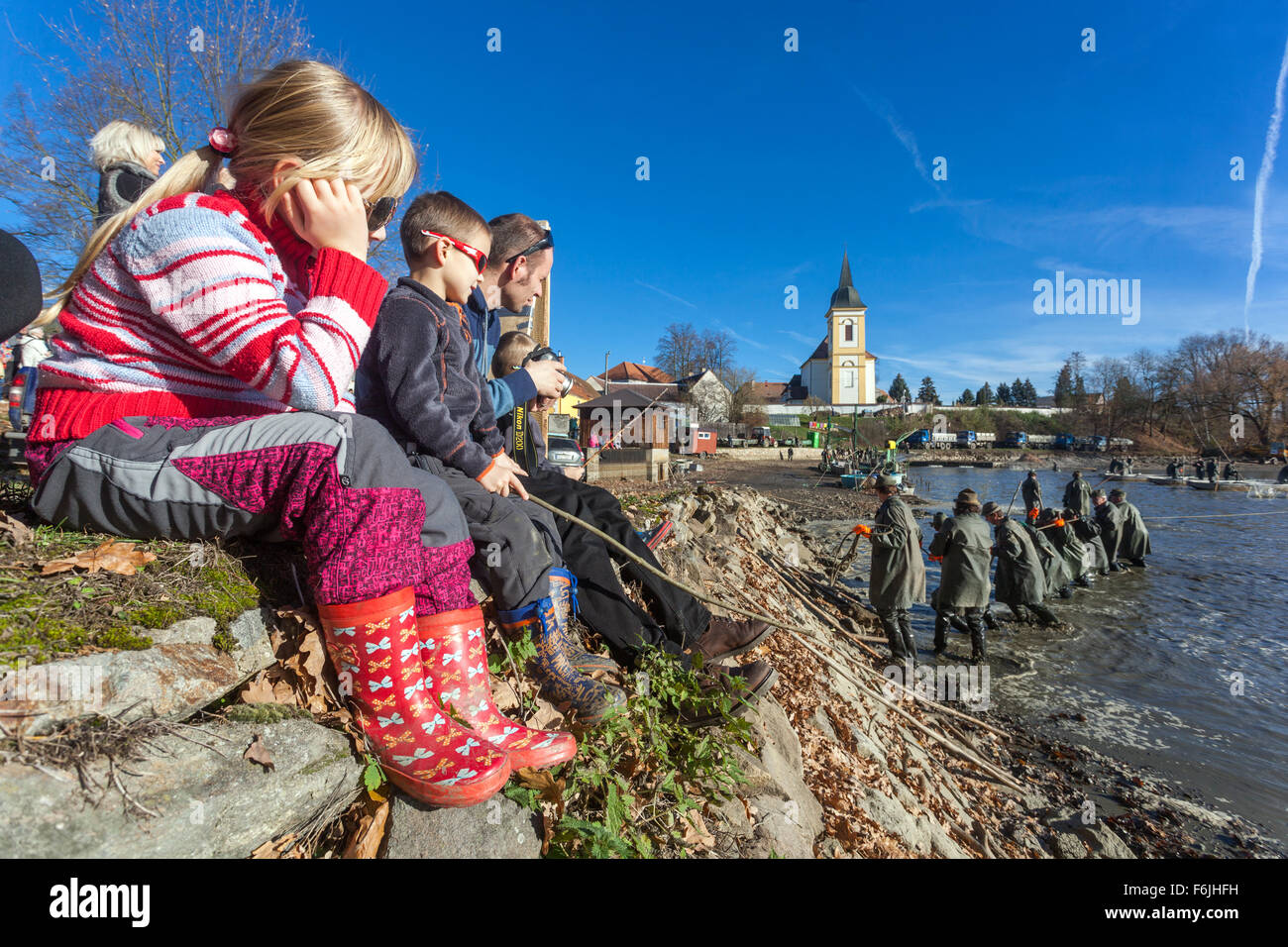 Les enfants sur la digue regarder les récoltes traditionnelles de l'étang des carpes tchèque. Bosilec La Bohême du Sud, République Tchèque Banque D'Images