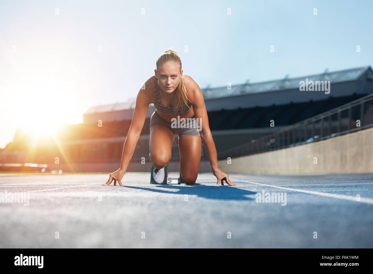 Certains jeunes femmes athlètes en position de départ prêt à démarrer un sprint. Femme sprinter prêt pour une course sur circuit avec su Banque D'Images