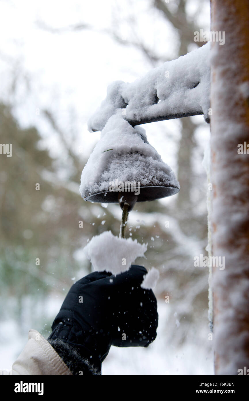 L'hiver une visite d'une maison couverte de neige sonne la cloche à l'ancienne et se fait sur la neige pour leur malheur Banque D'Images