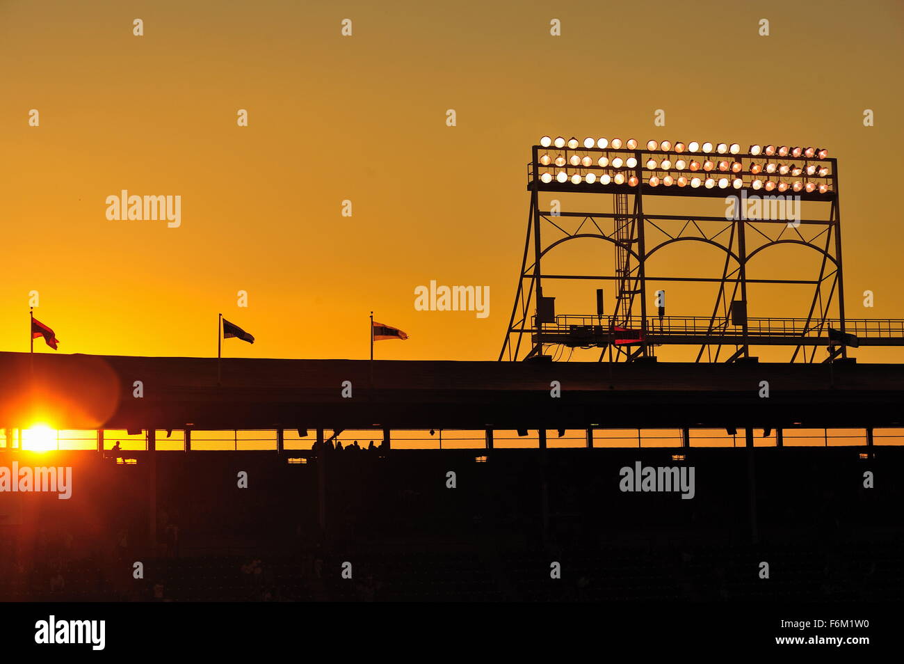 Le soleil se couche derrière le pont supérieur coin et tour monté sur le toit de Wrigley Field, stade des Chicago Cubs. Chicago, Illinois, USA. Banque D'Images