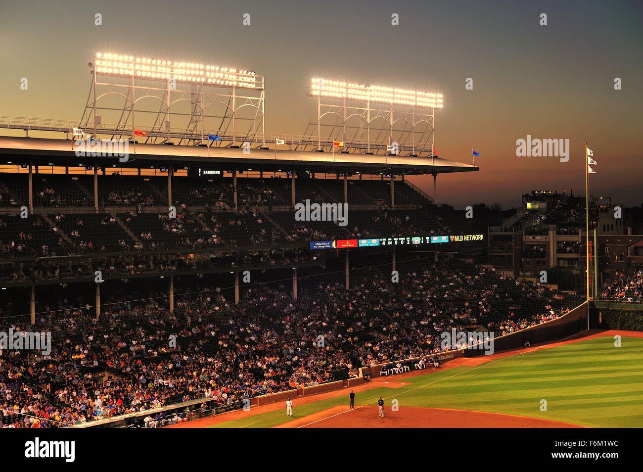 Le crépuscule tombe au-delà de la lumière des tours et le toit de Wrigley Field, stade des Chicago Cubs, sur une belle soirée d'été. Chicago, Illinois, USA. Banque D'Images