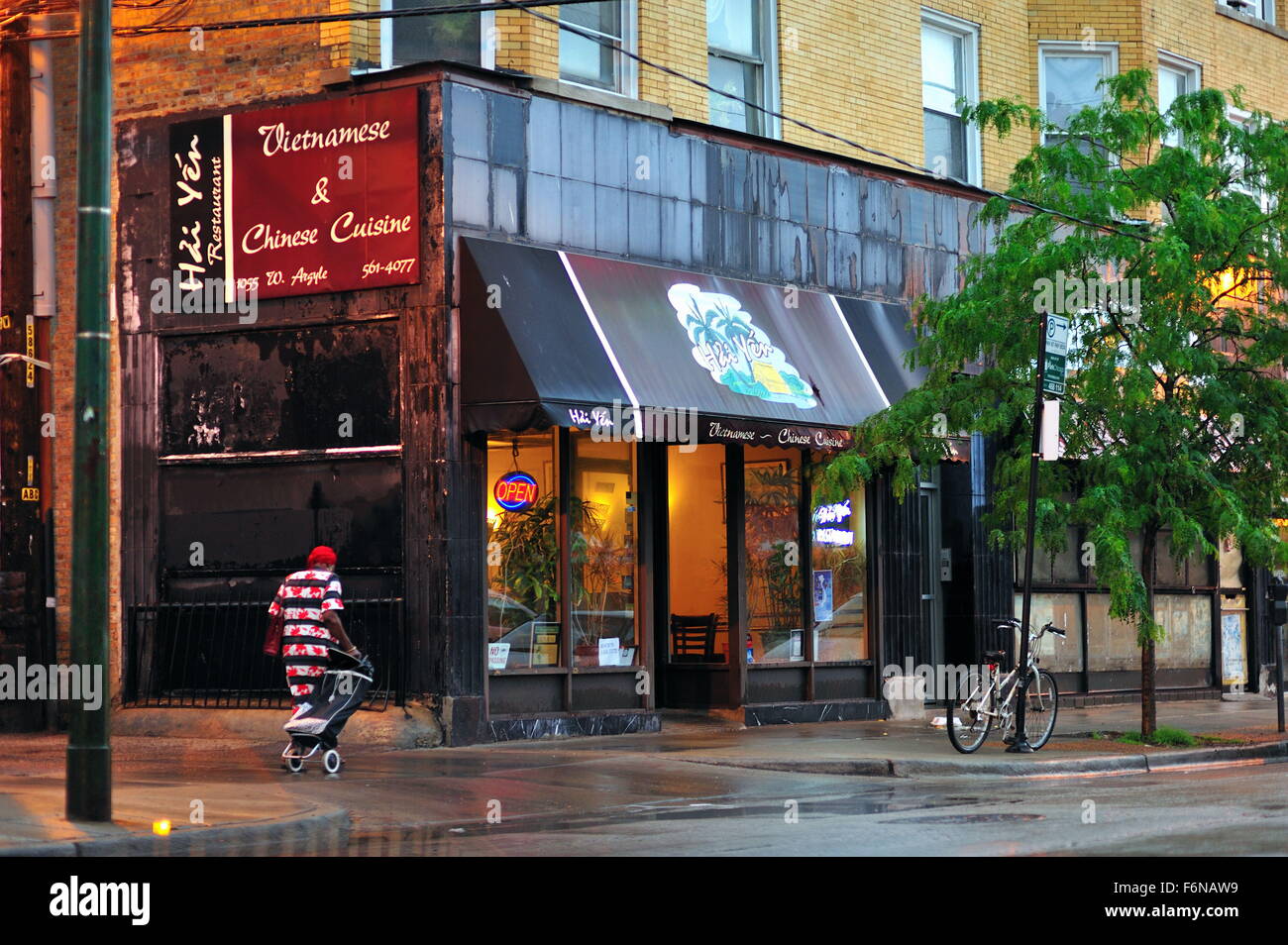 Après une soirée d'orage dans le quartier Uptown sur Argyle Street un piéton solitaire suit un trottoir. Chicago, Illinois, USA. Banque D'Images