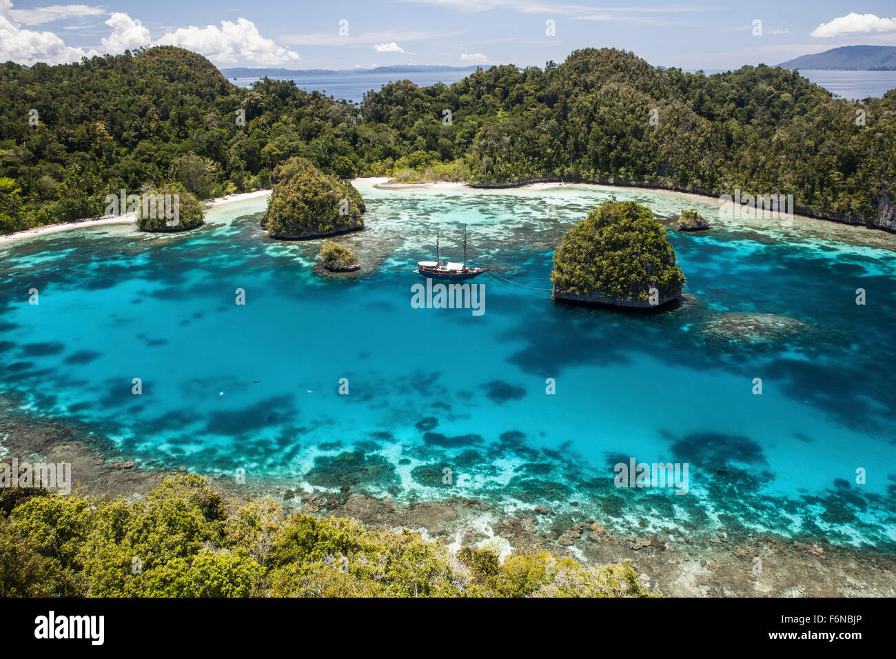 Pinisi indonésien est une goélette à l'ancre dans un lagon magnifique dans une région éloignée de Raja Ampat, en Indonésie. Cette belle regi Banque D'Images
