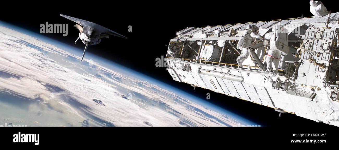 Une équipe d'astronautes effectuant des travaux sur une station spatiale tandis que la navette spatiale à la station d'approches lentement. Banque D'Images