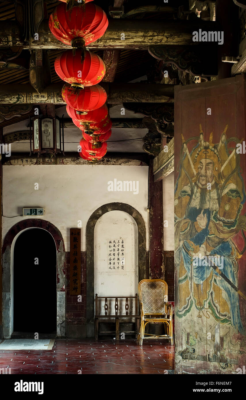 A l'intérieur d'un temple taïwanais avec une porte archée, des lanternes rouges et une peinture d'un gardien Banque D'Images