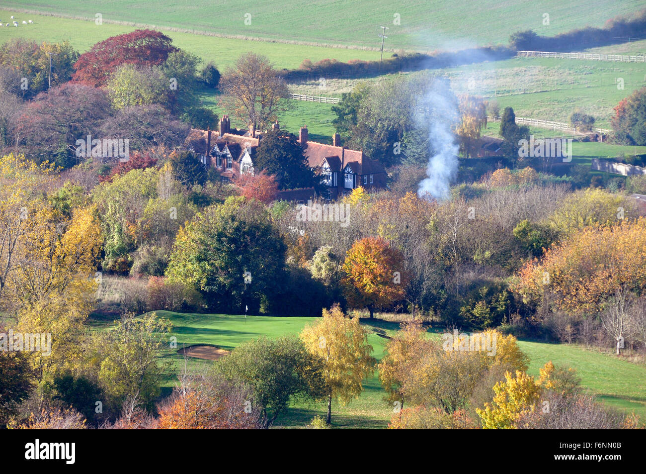 Argent - Chiltern Hills - Coombe sur colline - vue sur l'automne dans les arbres - cottages toits - propagation de la fumée d'un feu de joie Banque D'Images
