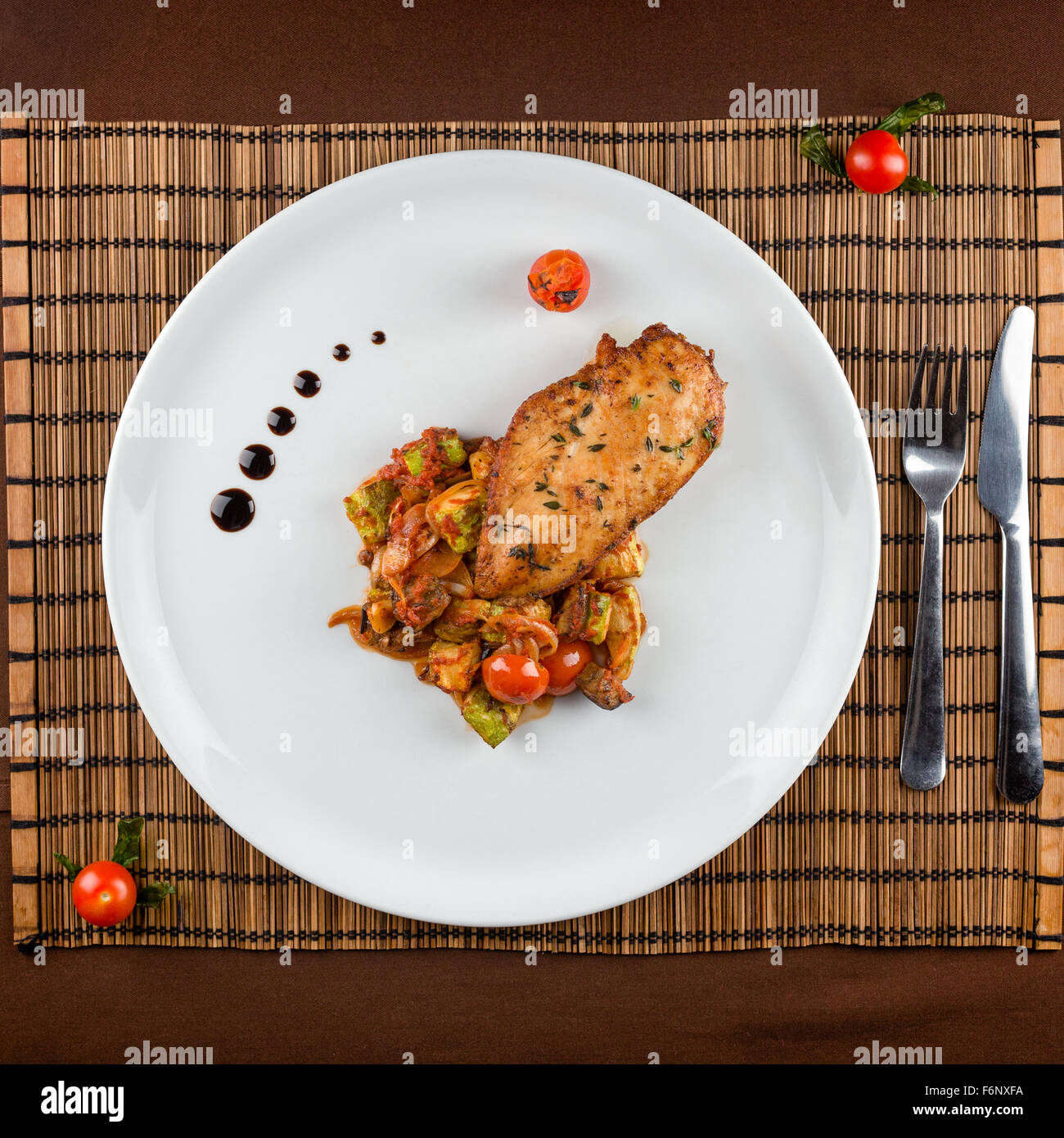 Poitrine de poulet cuit avec Ratatouille dans un plat blanc sur la table Banque D'Images