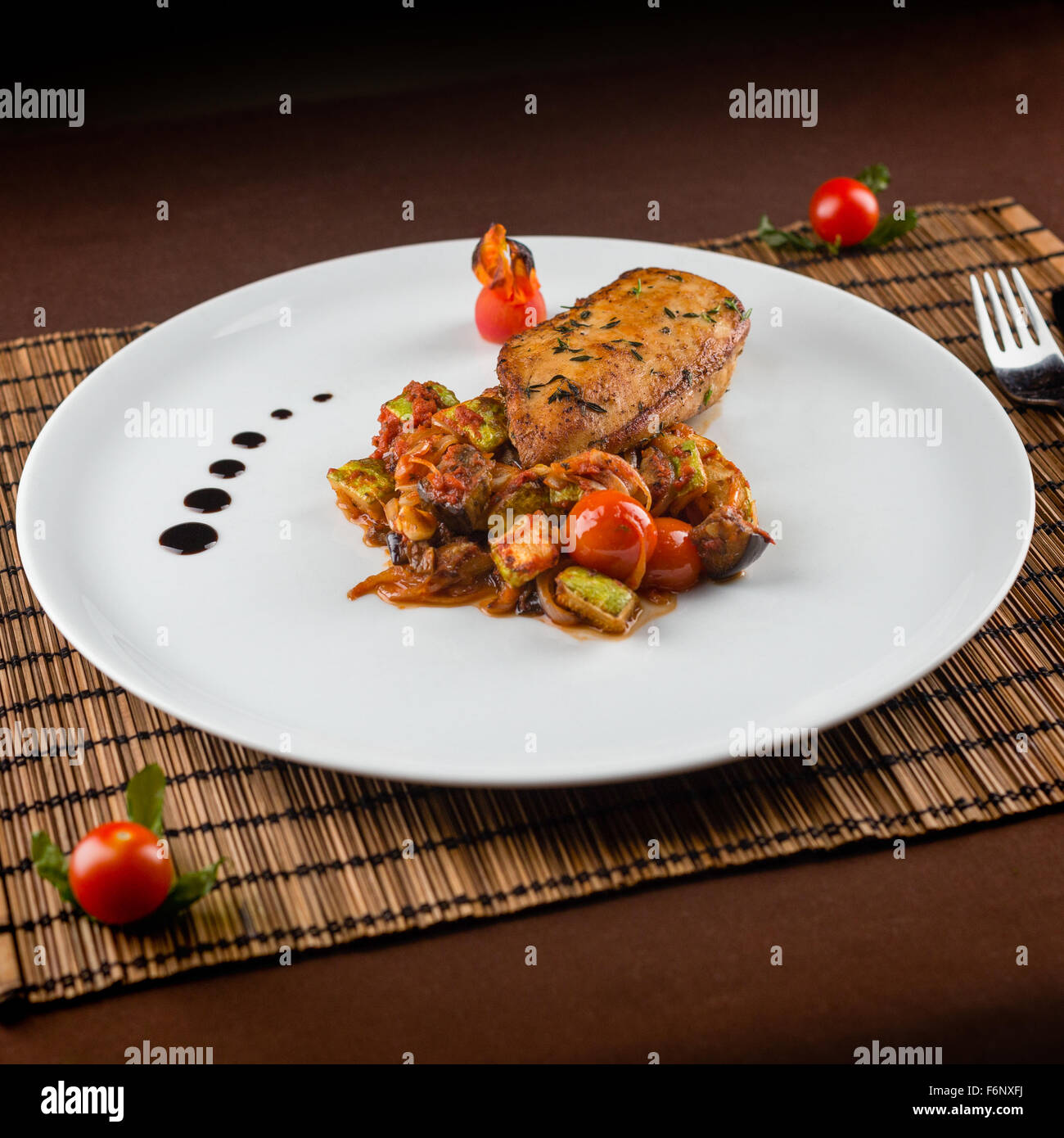Poitrine de poulet cuit avec Ratatouille dans un plat blanc sur la table Banque D'Images