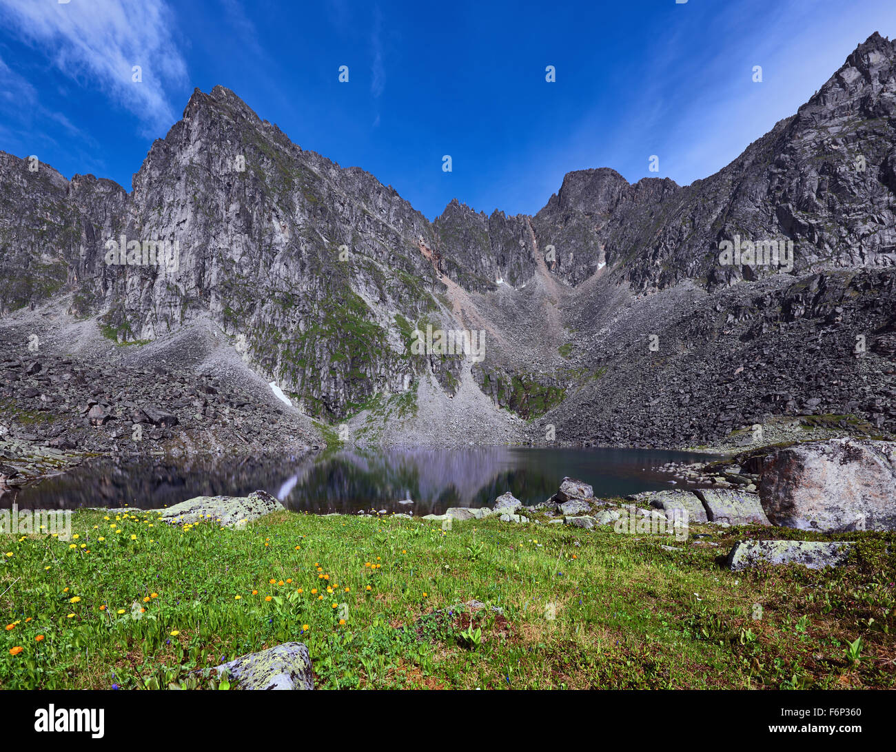Petite prairie près d'un lac de montagne dans l'arrière-plan d'une chaîne de montagnes le long d'une journée d'été. Sayan de l'Est. La Bouriatie Banque D'Images