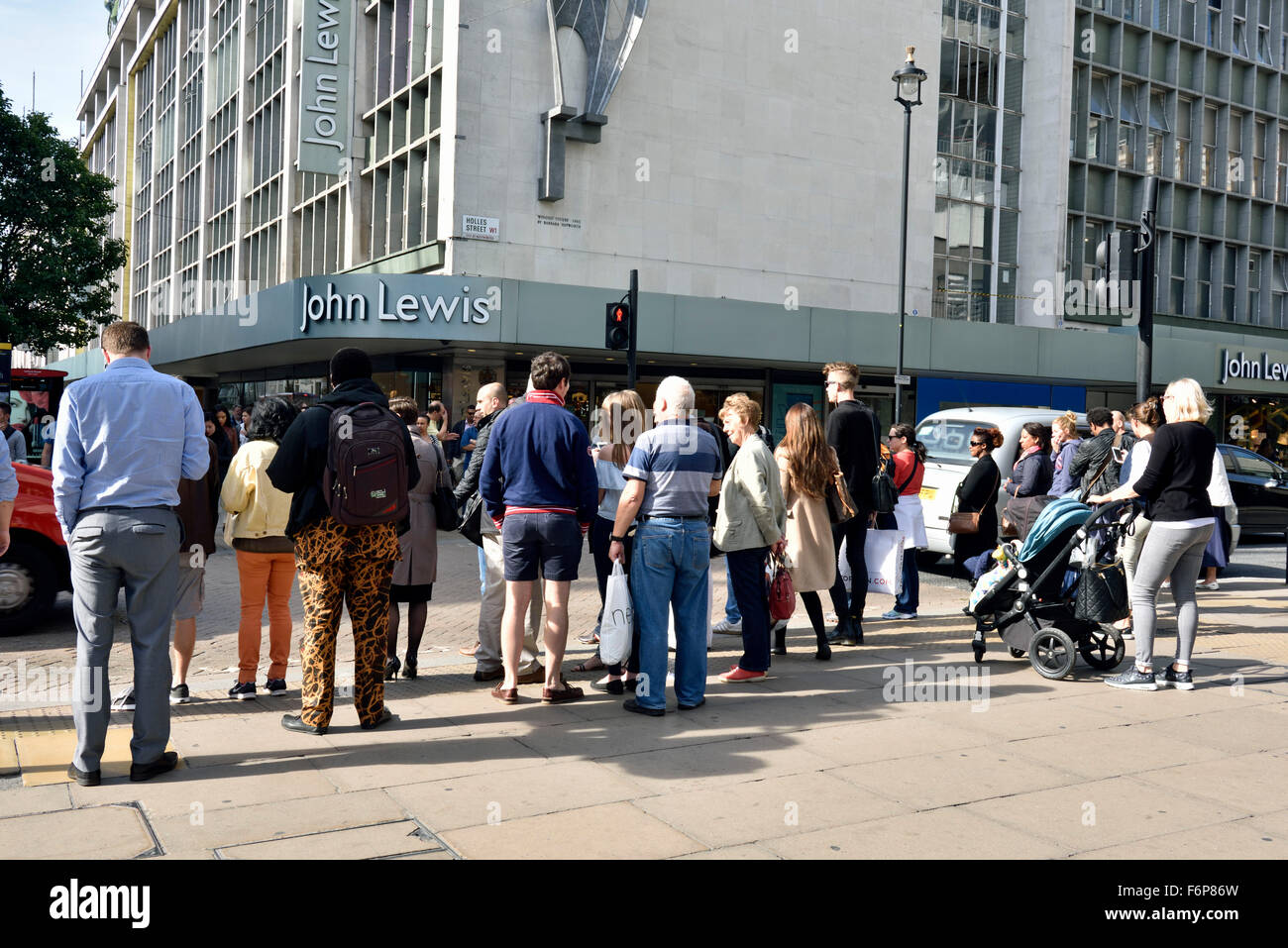 Les personnes en attente de traverser la route en face de John Lewis Oxford Street, Central London England Angleterre UK Banque D'Images