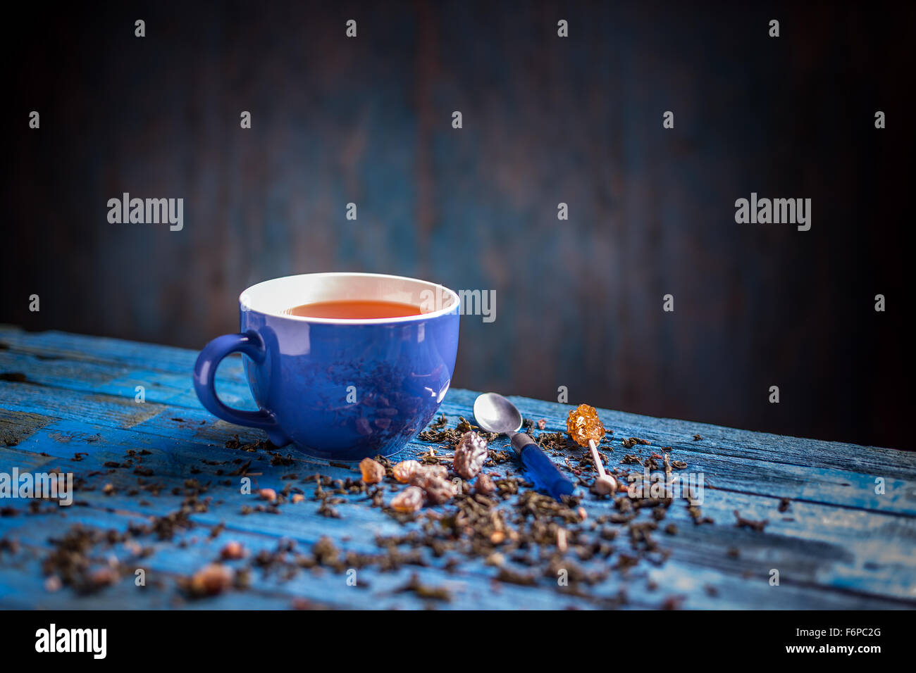 Tasse de thé noir avec bleu sur bleu table en bois Banque D'Images