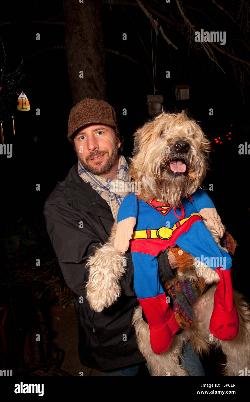 Maître Halloween avec son chien dans un costume de superman trick ou traiter. St Paul Minnesota MN USA Banque D'Images