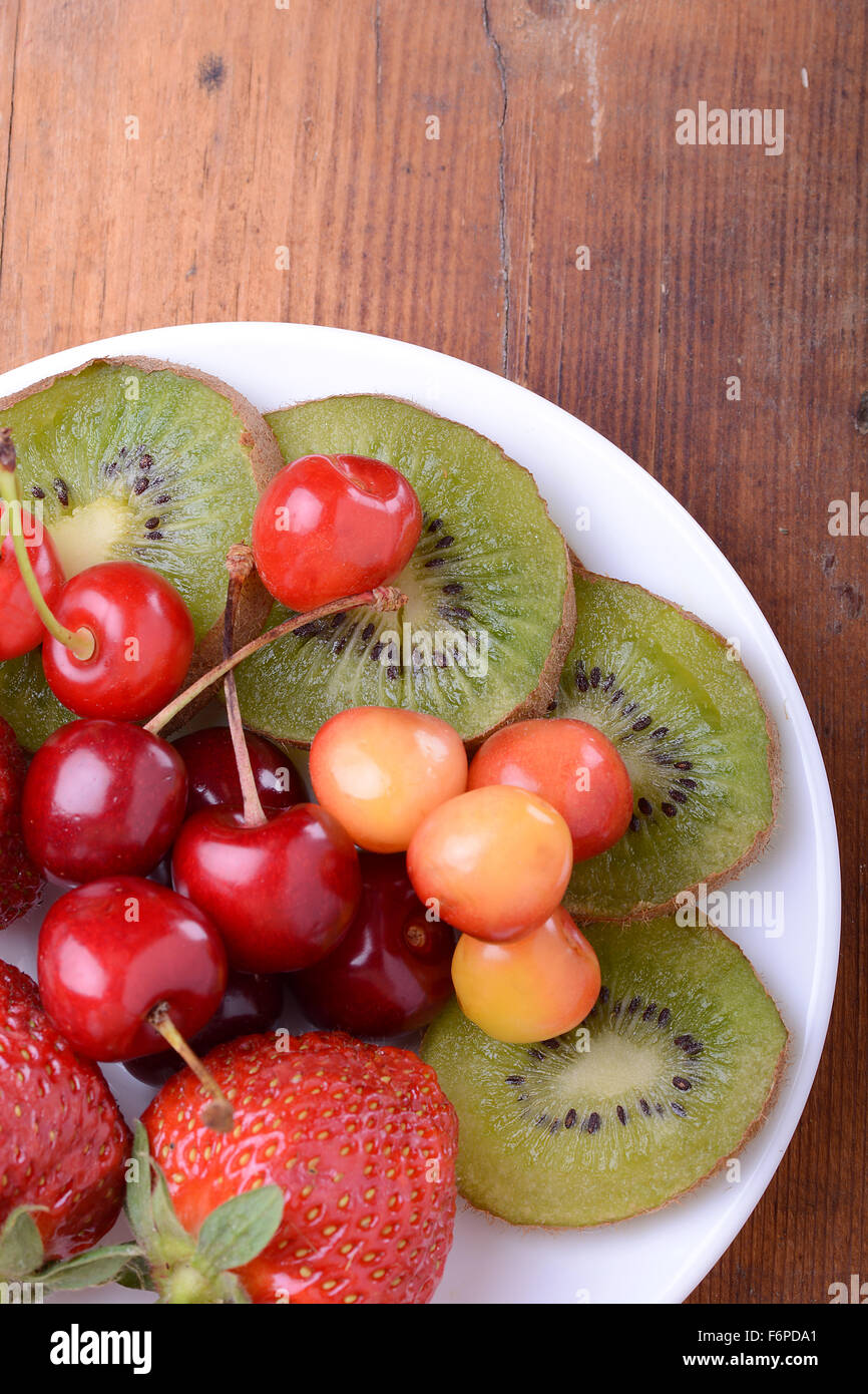 Fruits santé avec cerise, fraise, kiwi sur plaque de bois Banque D'Images