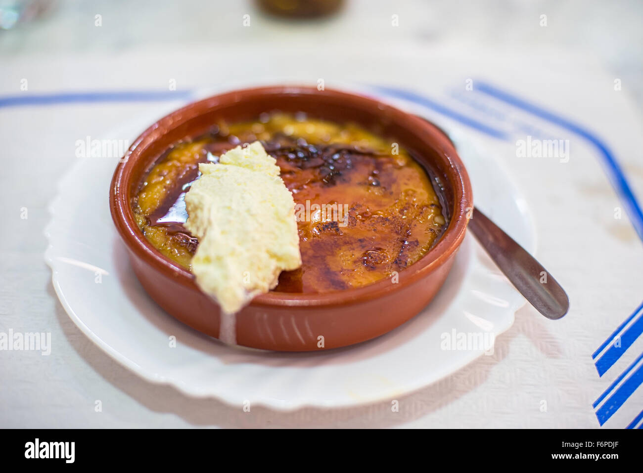 Crème catalane ou crème brûlée dans un bol rustique, typique taberna bistro ou présentation par une cuillerée de chantilly. Des traditionnels Banque D'Images