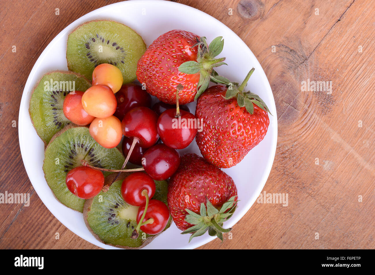 Fruits santé avec cerise, fraise, kiwi sur plaque de bois Banque D'Images