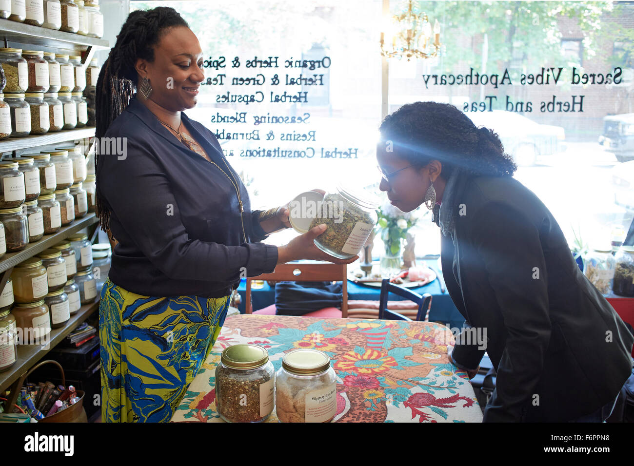 Black woman smelling plateau en magasin de thé Banque D'Images