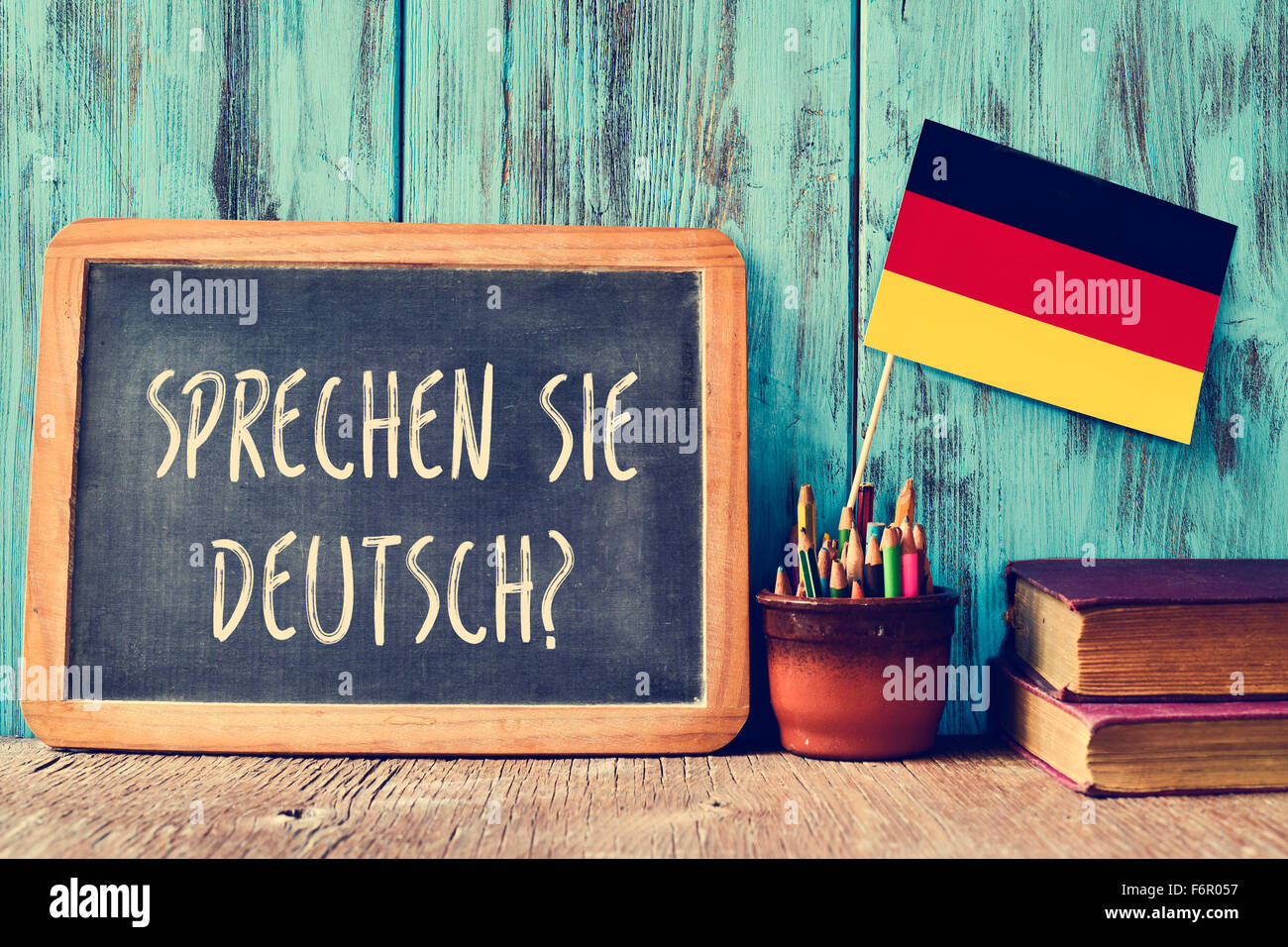 Un tableau sur la question Sprechen Sie Deutsch ? Parlez-vous allemand ? Rédigé en allemand, un pot avec des crayons, des livres et Banque D'Images
