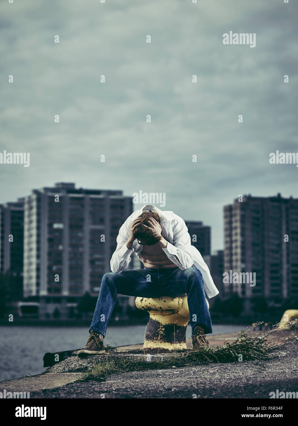 Bel homme portant une chemise blanche et un jean, jour de vent dans le port Banque D'Images