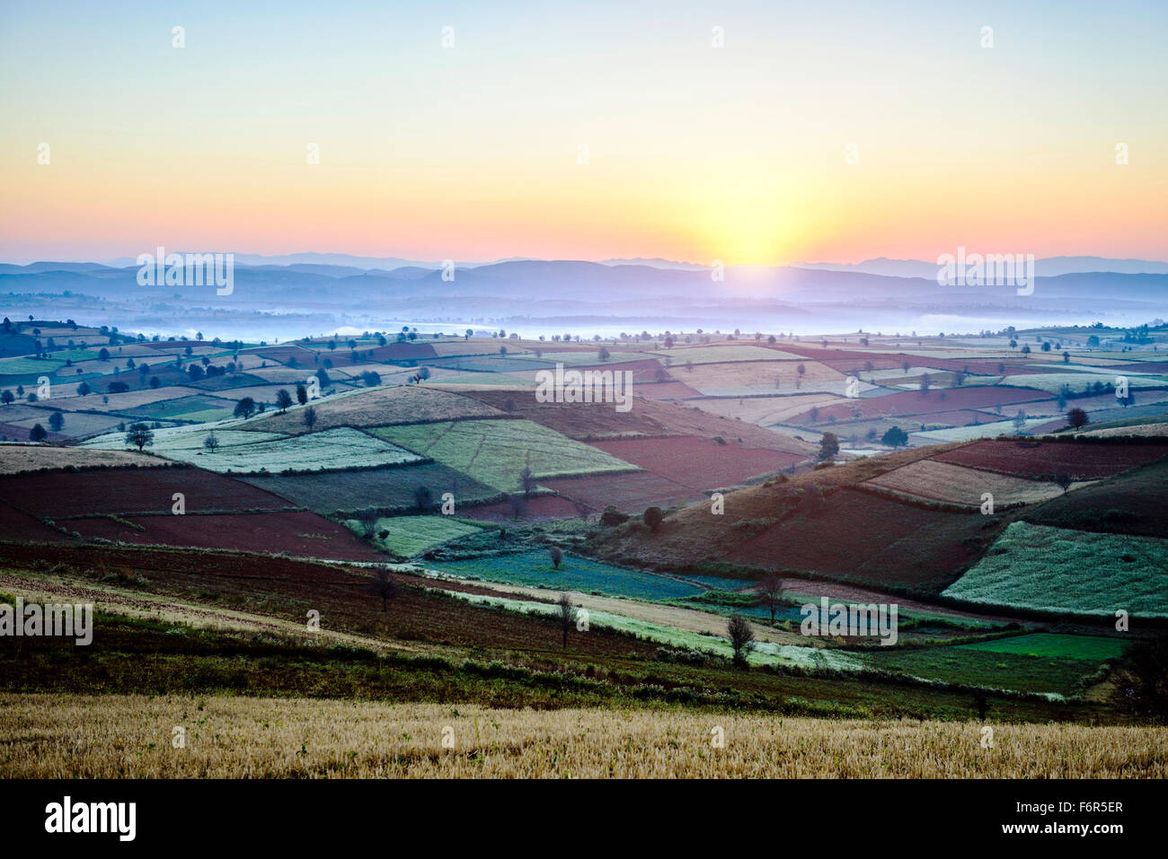 Le lever du soleil sur les terres agricoles en paysage rural Banque D'Images