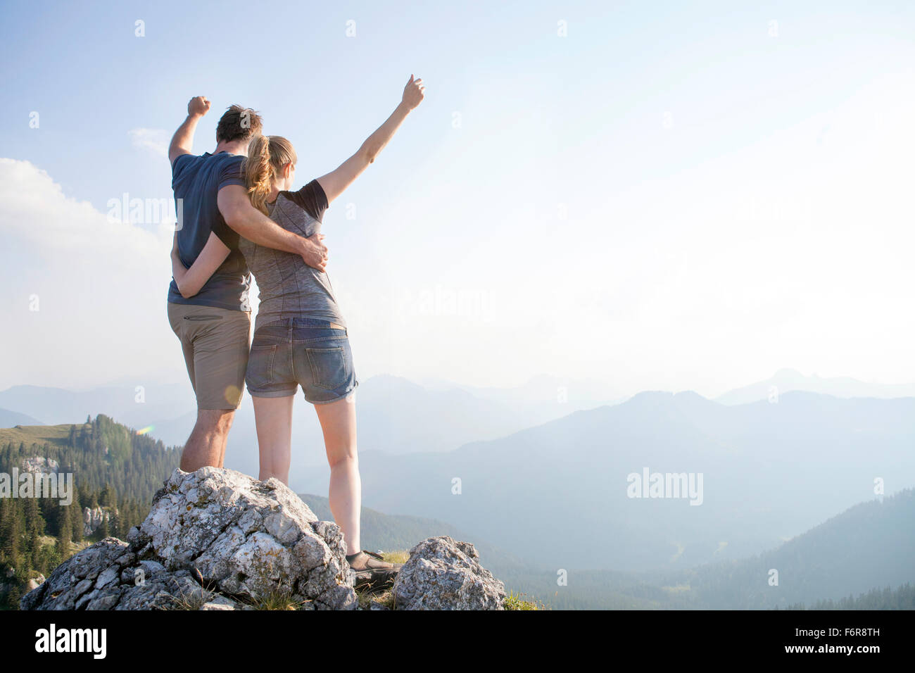 Jeune couple cheering sur sommet de montagne Banque D'Images