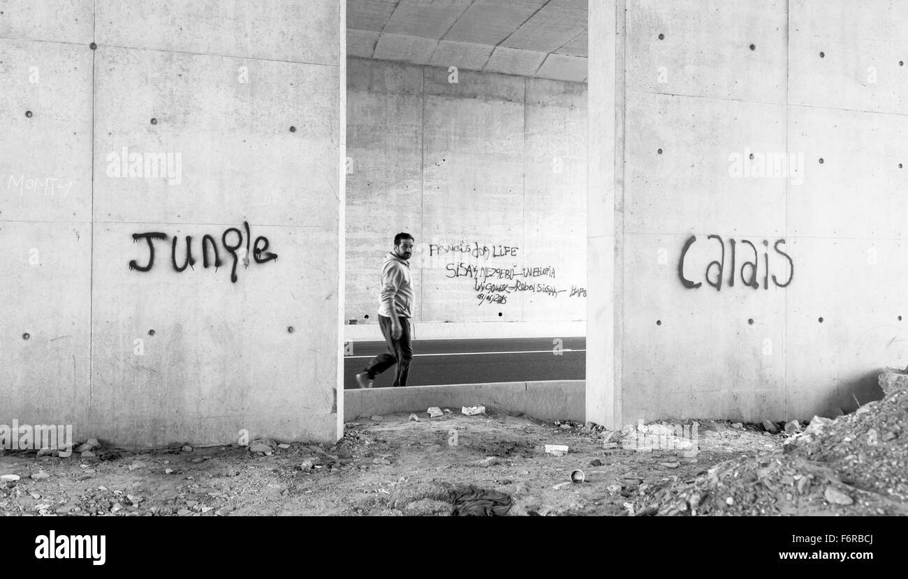 La jungle camp de réfugiés. Le migrant fait son chemin passé graffitis. Banque D'Images