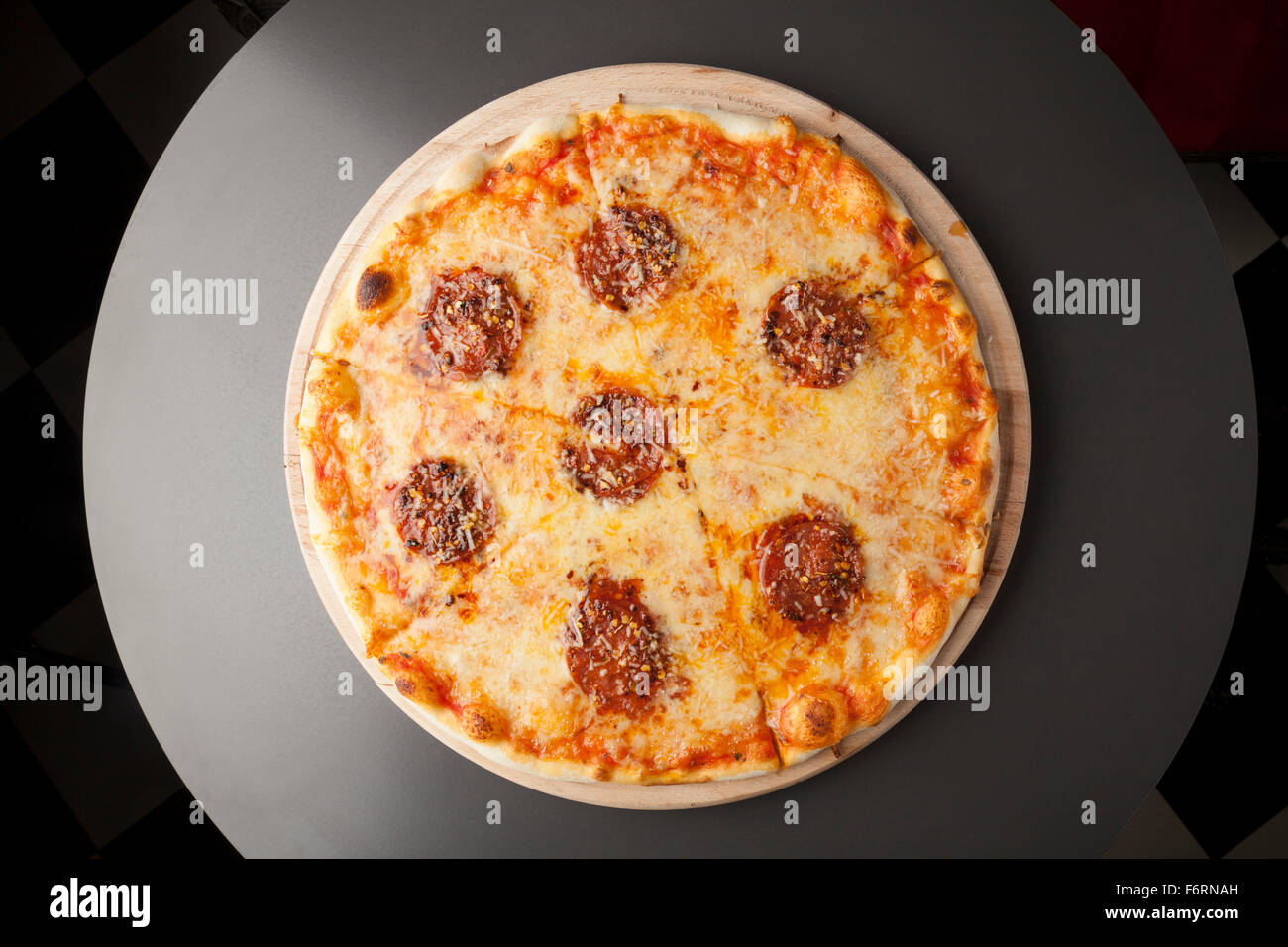 Pizza au pepperoni, avec de la saucisse sur plaque de bois Banque D'Images