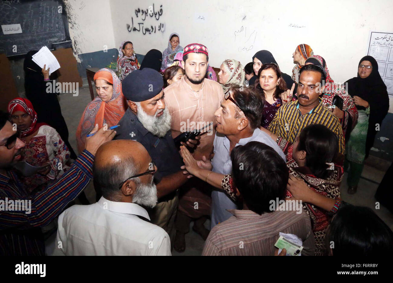 Des responsables de la sécurité et Présidents de bureau de vote clair essayer après l'affrontement entre les hommes et les électeurs au cours des élections locales (2015) à Hyderabad le Jeudi, Novembre 19, 2015. La deuxième phase des élections des organes locaux sont en cours dans 26 districts du Sindh et du Pendjab. Le scrutin a débuté à 7h30 et se poursuivra jusqu'à 17h30. Un certain nombre de plaintes ont été reçues de retard de l'interrogation pour misprinting des bulletins de vote. Banque D'Images