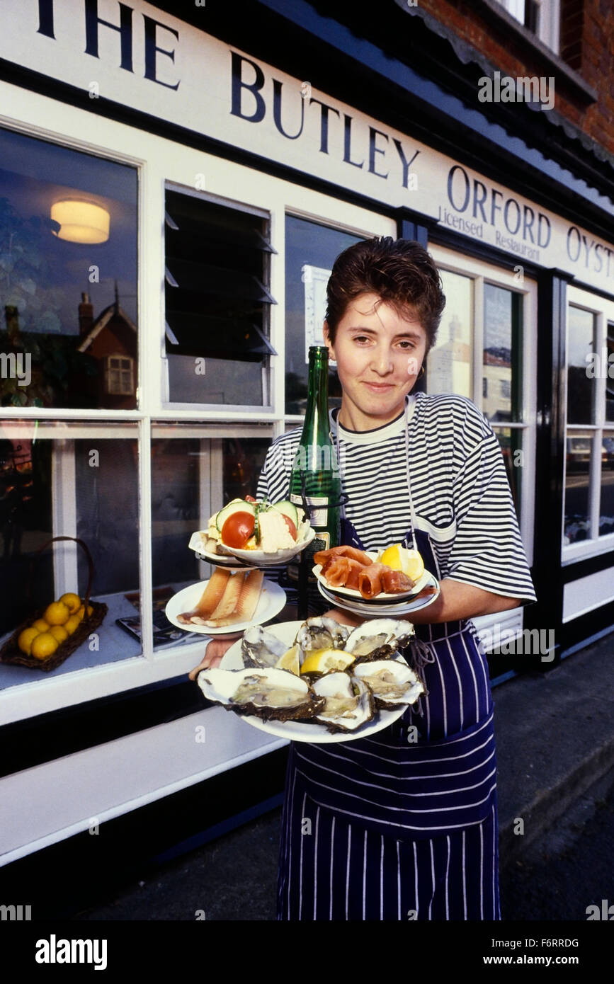 Une serveuse avec une sélection d'huîtres fraîches et le poisson fumé à l'Orford Butley Oysterage. Le Suffolk. L'Angleterre. UK Banque D'Images