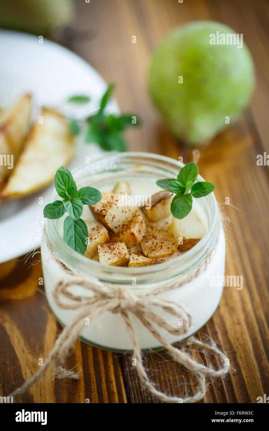 Le yaourt avec les poires rôties dans un bocal en verre Banque D'Images