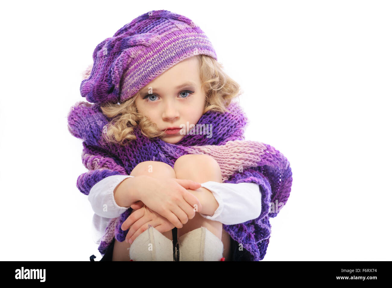 La jeune fille vêtue d'un violet vif foulard tricoté et hat.Elle a peint les lèvres et les yeux,comme la fille adultes.Il est triste et rire Banque D'Images