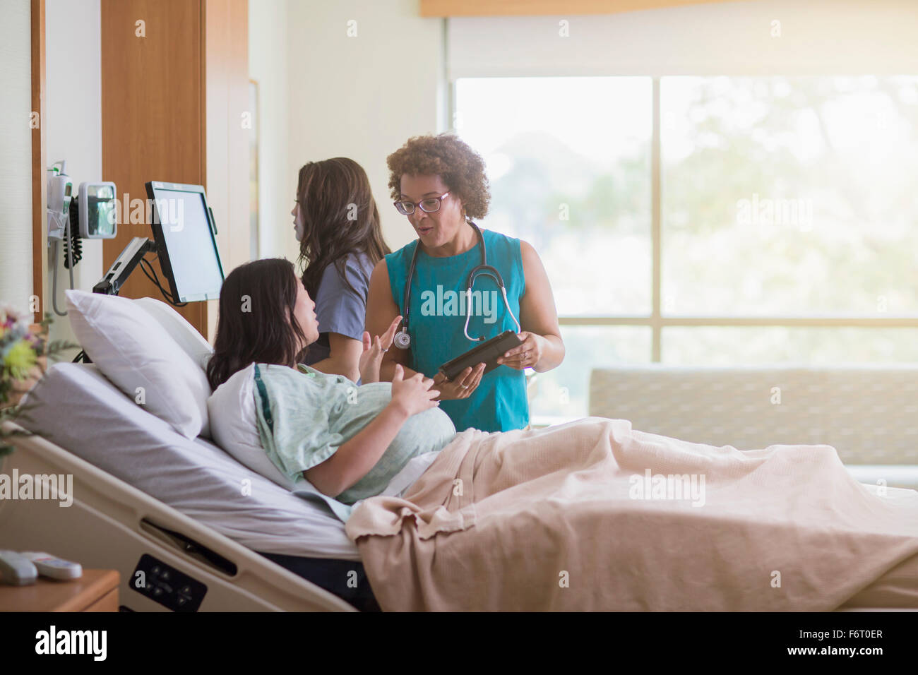 Doctor talking to patient in hospital room enceintes Banque D'Images