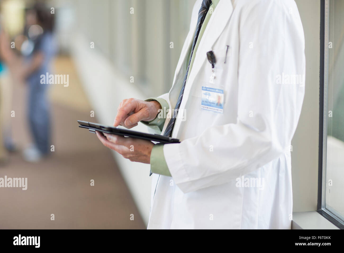 Doctor using digital tablet in hallway Banque D'Images