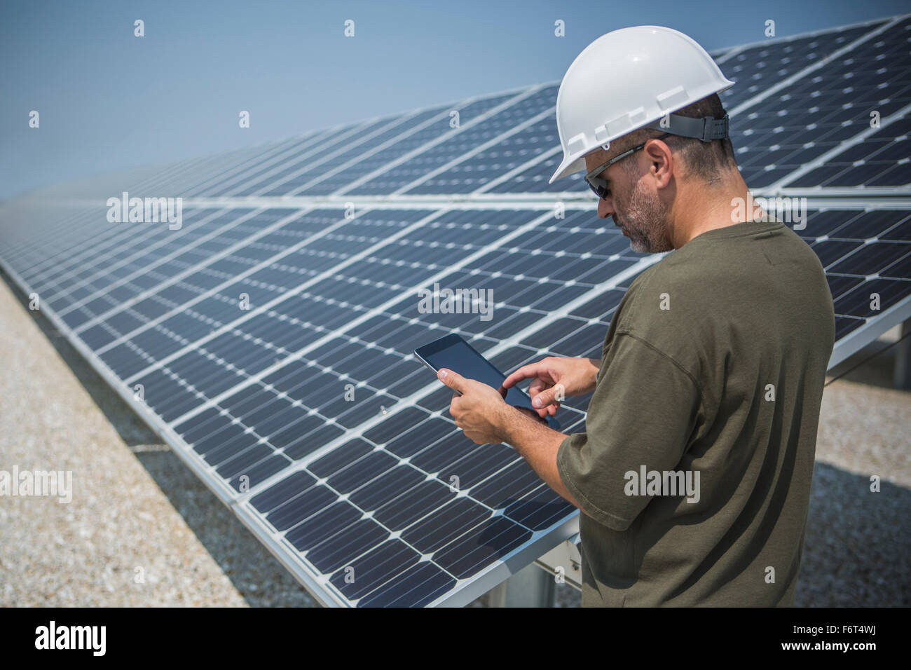 Technicien caucasienne using digital tablet près de panneaux solaires Banque D'Images