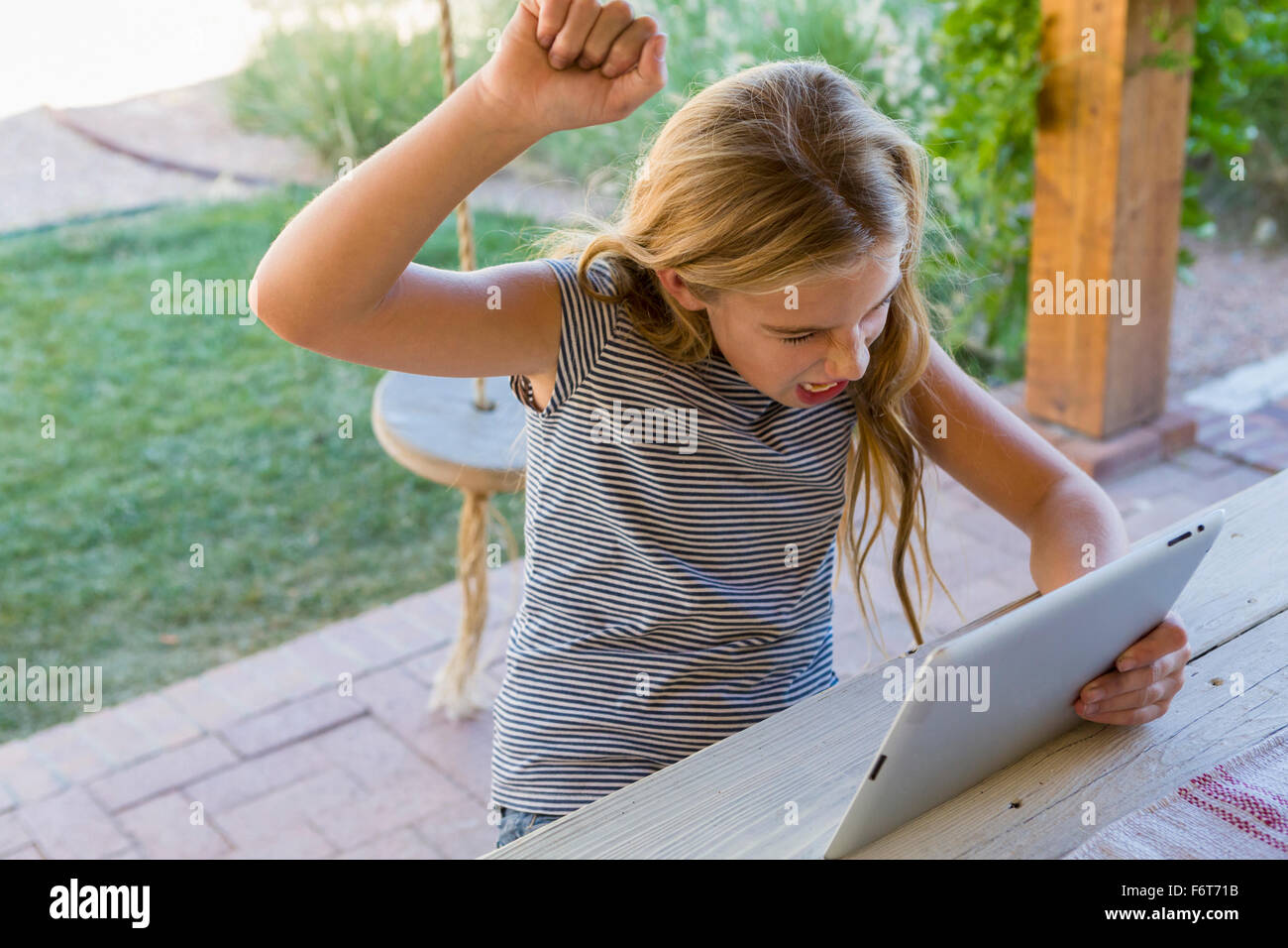 Woman cheering at digital tablet Banque D'Images