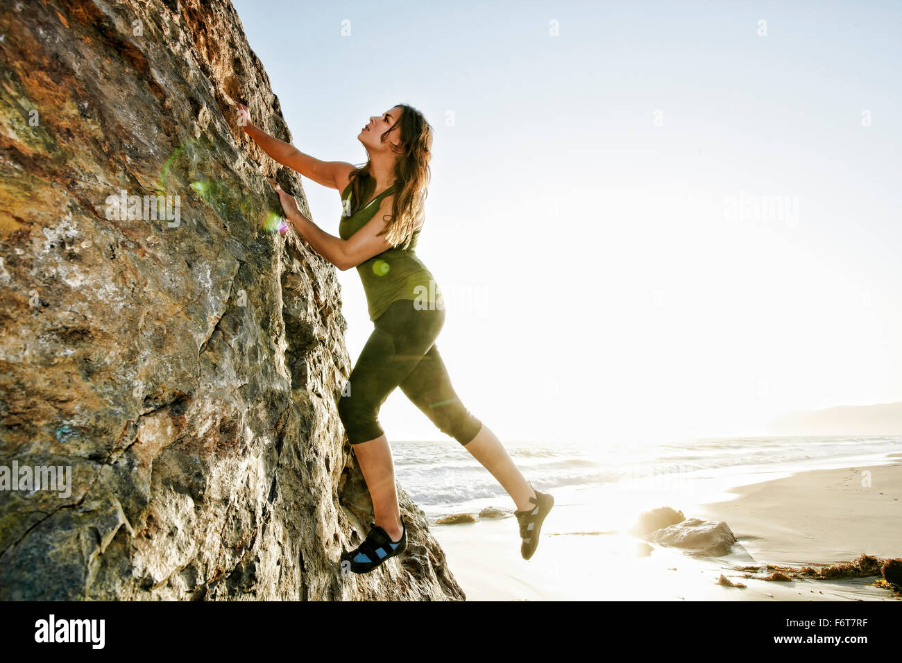 Woman climbing rock formation Banque D'Images