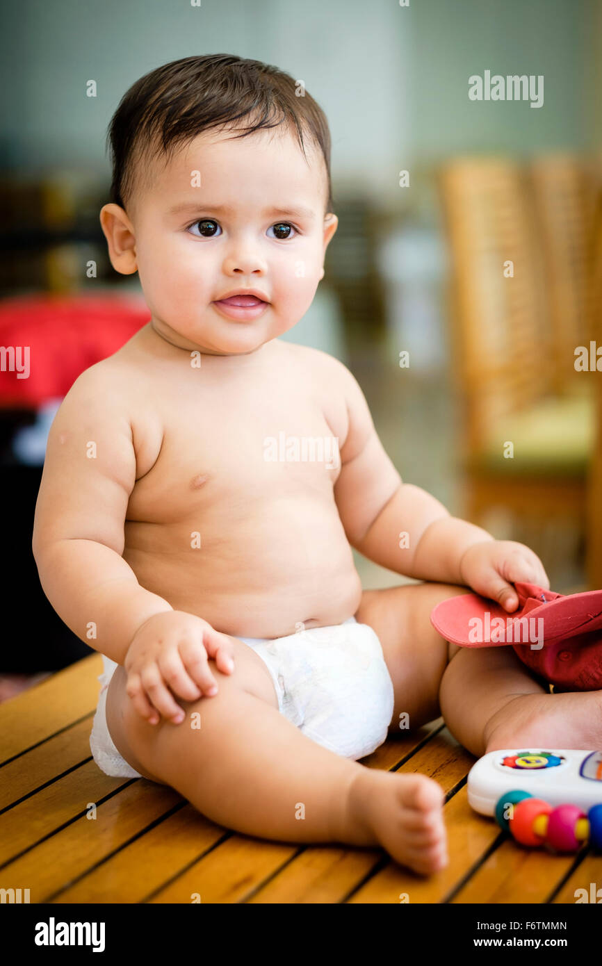 Portrait de bébé garçon assis sur une table en couches Photo Stock - Alamy