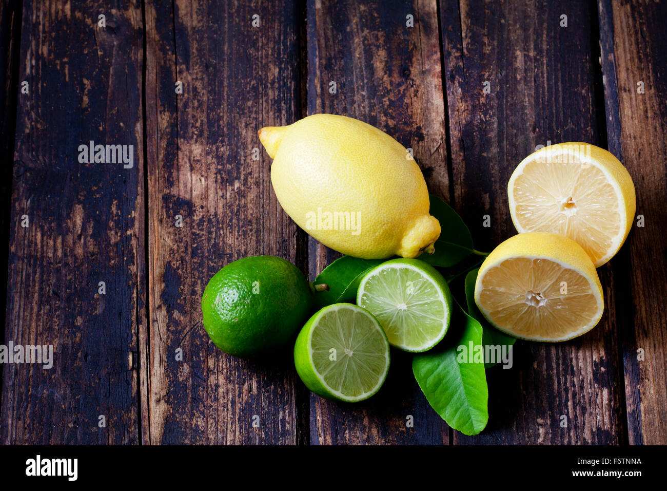 Ensemble et les tranches de citrons et limes sur bois foncé Banque D'Images