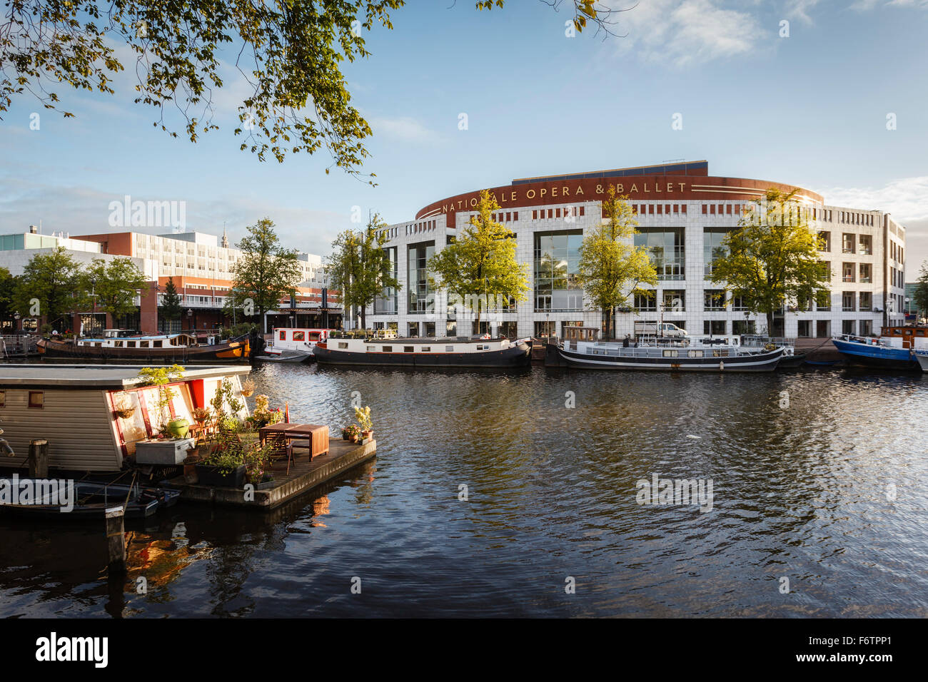 Pays-bas, Amsterdam, péniche au bord de la rivière Amstel avec Het Muziektheater en arrière-plan Banque D'Images
