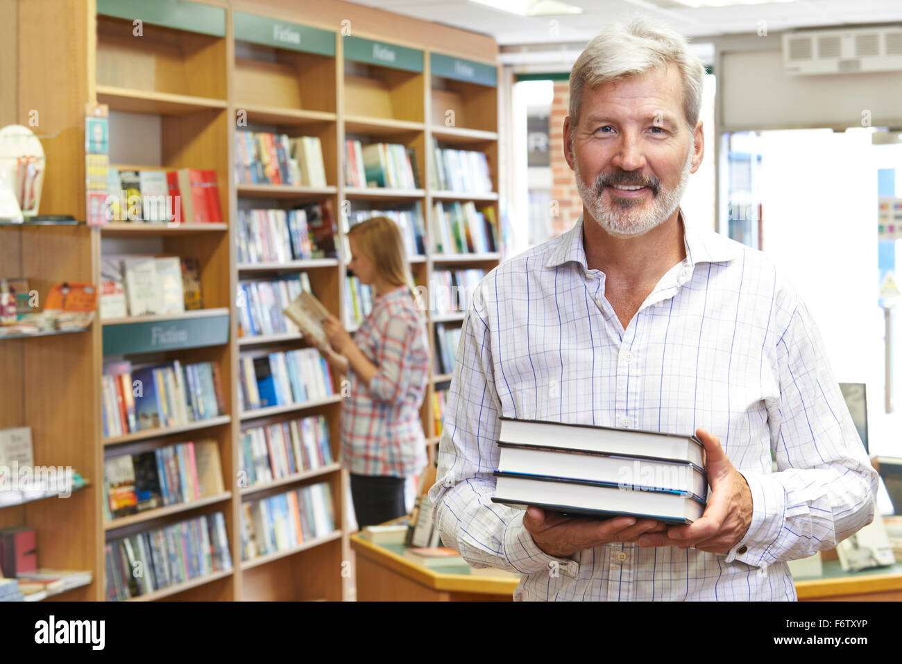 Portrait de l'homme propriétaire de la librairie avec le client en arrière-plan Banque D'Images