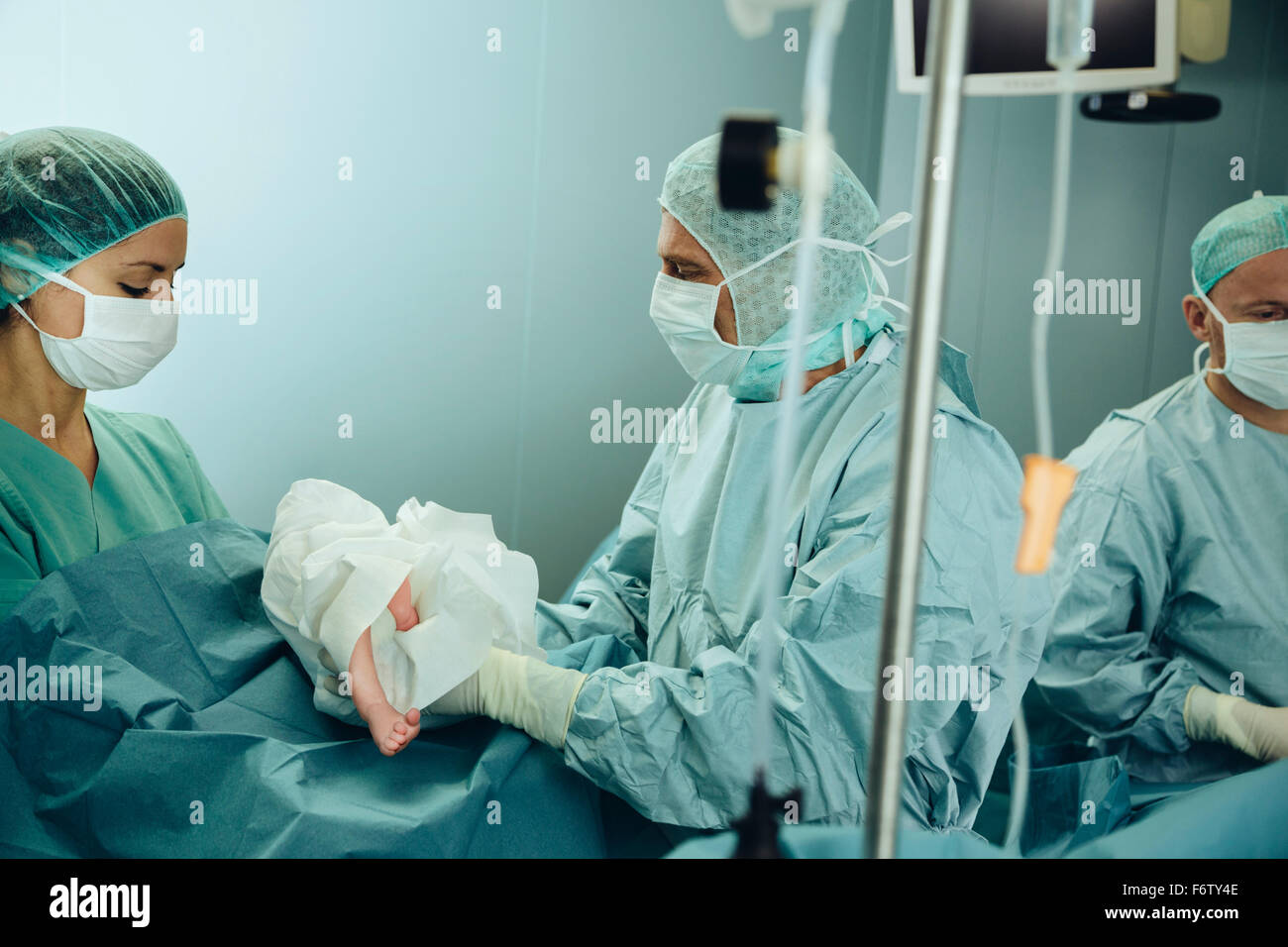 Chirurgien remise nouveau-né à l'infirmière de salle d'opération après c-section Banque D'Images