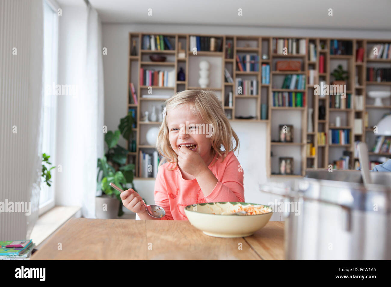 Portrait of laughing little girl eating spaghetti Banque D'Images