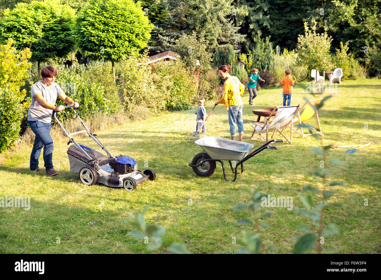 Père de tondre la pelouse dans le jardin Banque D'Images