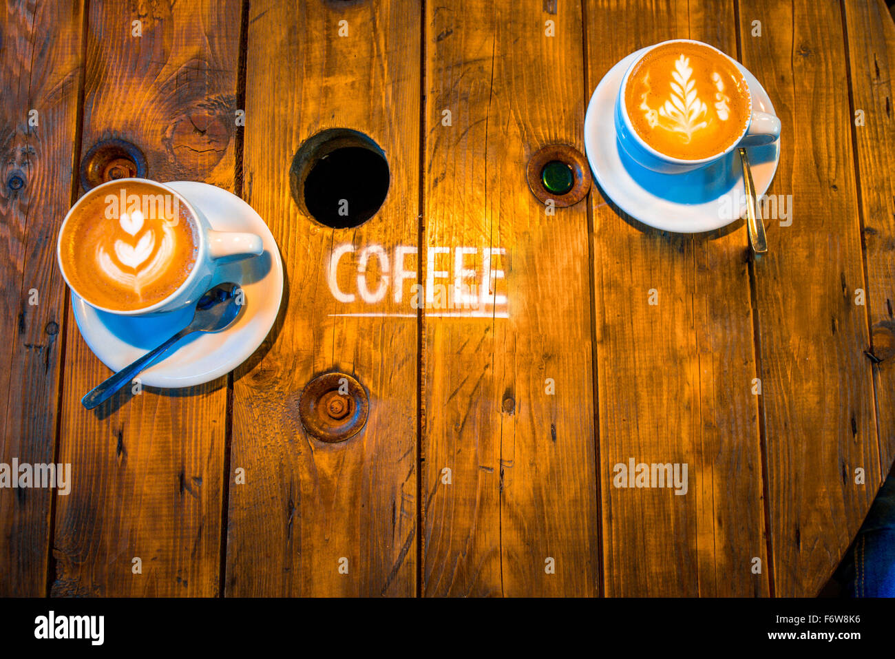 Des tasses de Cappuccino avec belle forme d'art sur la table en bois Banque D'Images