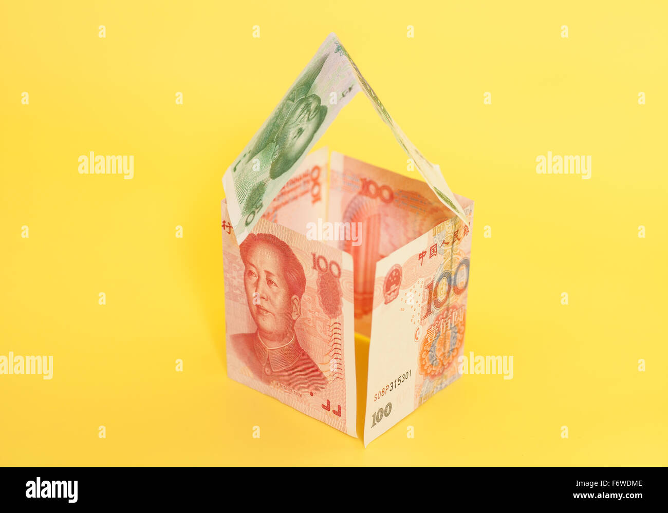 Maison faite de billets yuan chinois sur fond jaune Banque D'Images
