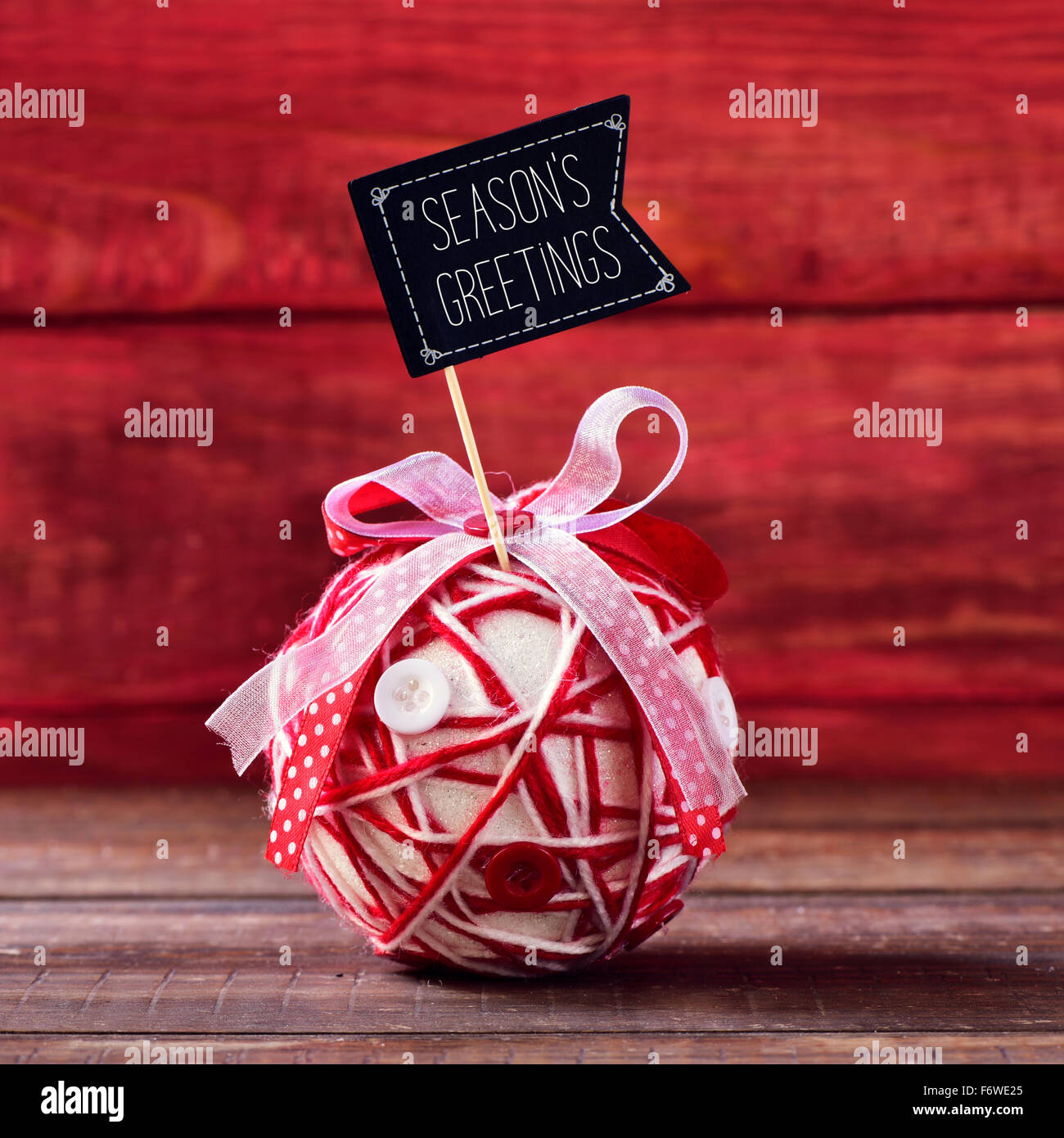 Un bal de Noël artisanal, fabriqué avec différents rubans et boutons, surmontée d'une pancarte en forme de drapeau avec les saisons texte gr Banque D'Images