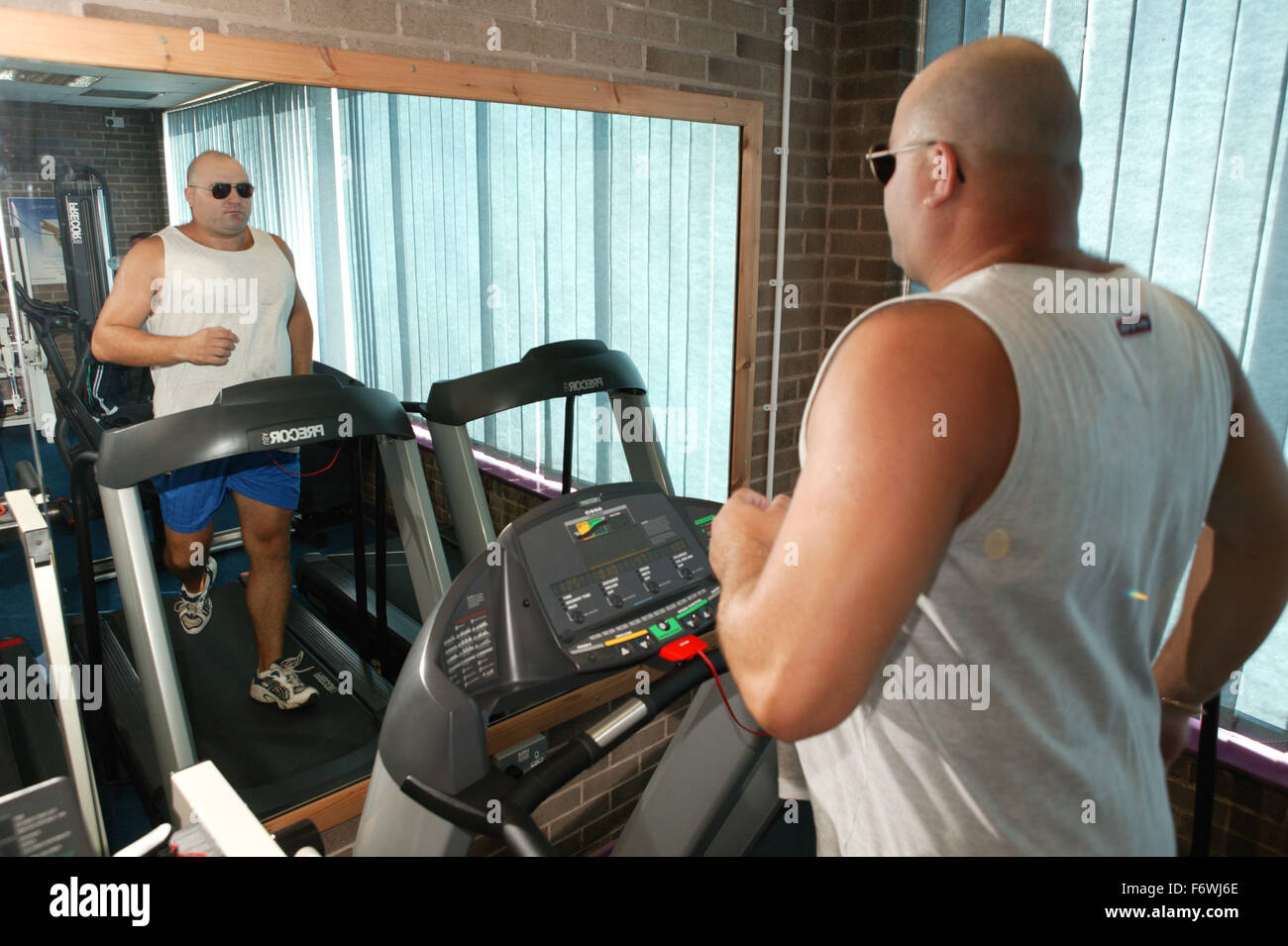 L'accès aux services, l'homme handicapé dans la salle de sport ; à l'aide de tapis roulant, Banque D'Images