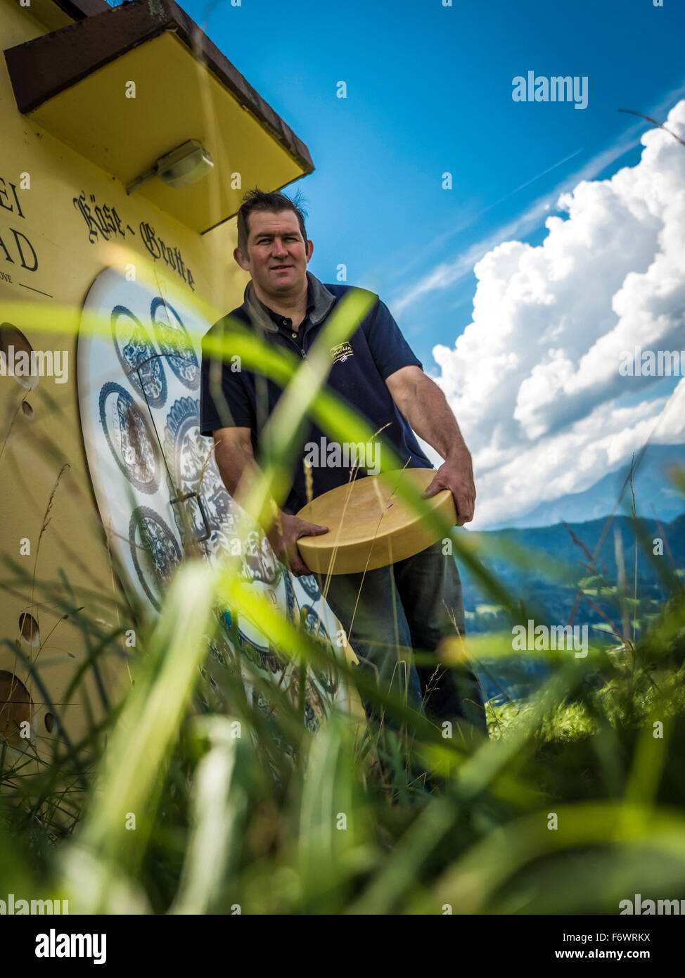 Homme portant une roue de fromage, fromage chambre de maturation dans un ancien réservoir d'eau, Gstaad, Canton de Berne, Suisse Banque D'Images