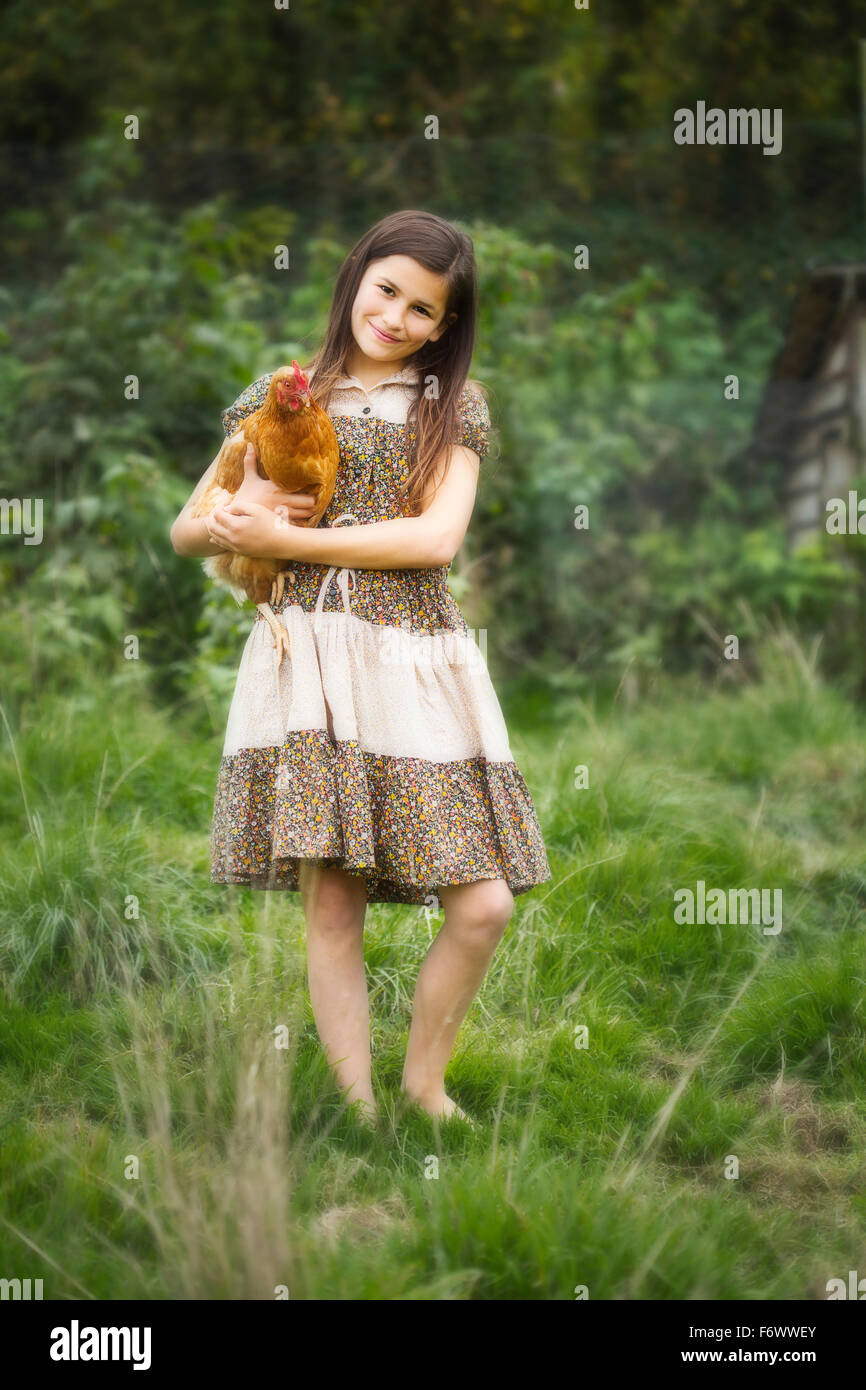 Une belle jeune fille de la campagne holing un poulet Banque D'Images