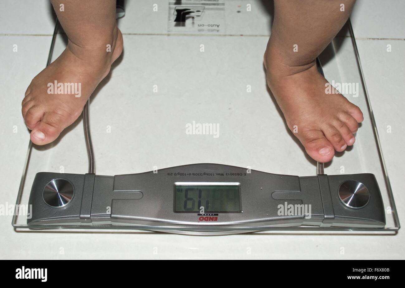 Une échelle de bain transparent numérique pour mesure du poids avec pieds de bébé Banque D'Images