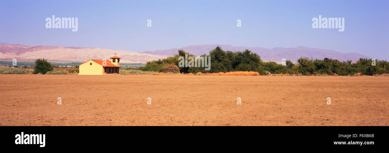 Un champ en jachère se trouve dans le premier plan avec une église de campagne, des champs verts et les montagnes au loin, Santa Ynez Valley Banque D'Images Un champ en jachère se trouve dans le premier plan avec une église de campagne, des champs verts et les montagnes au loin, Santa Ynez Valley Banque D'Images